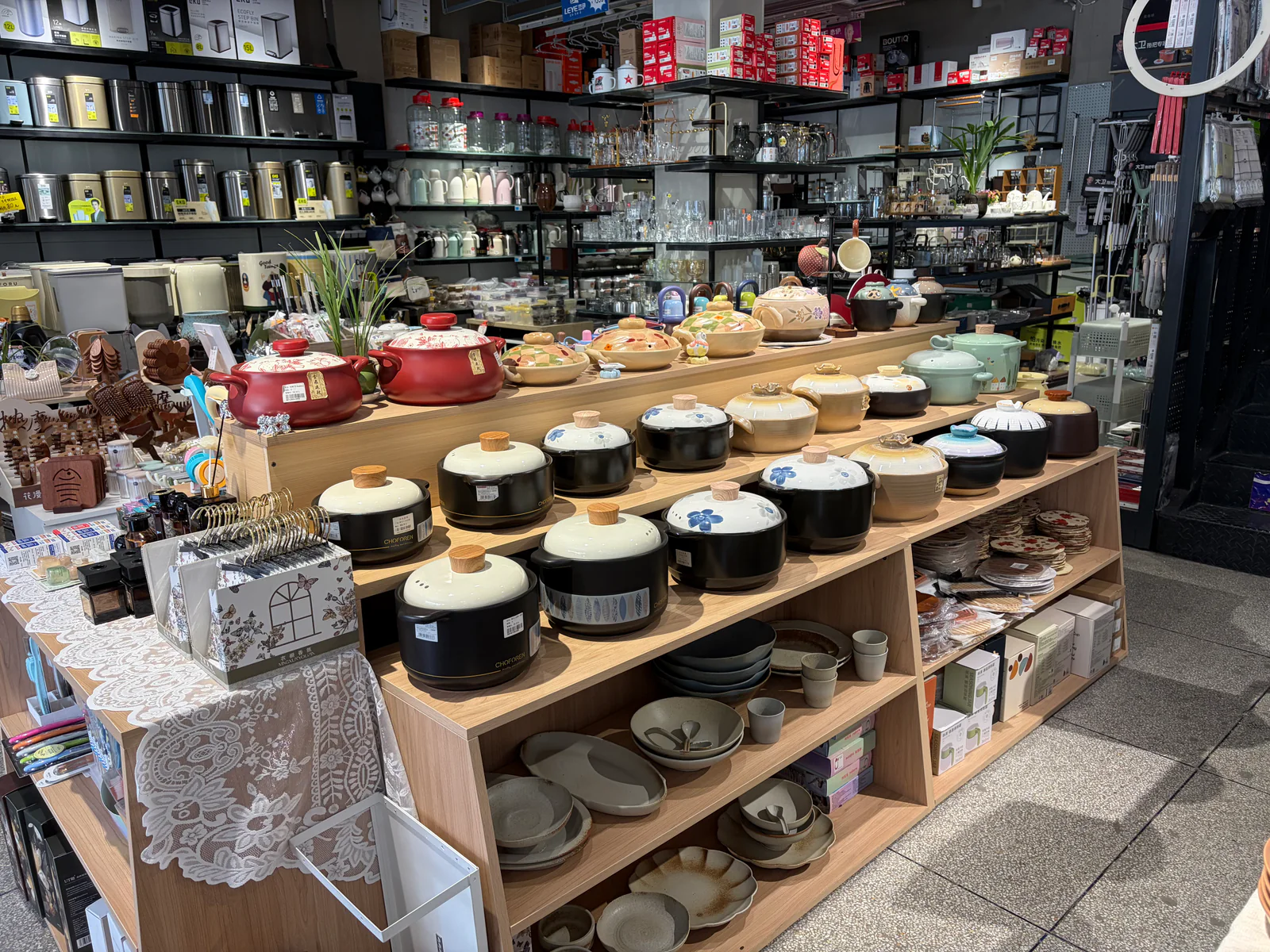 永兴家居百货店内整齐陈列的砂锅、炖锅和碗盘